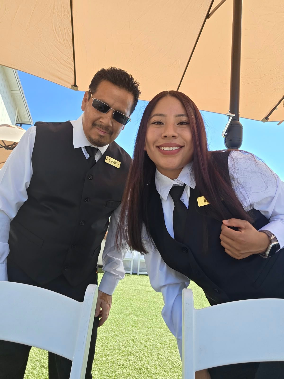 Two uniformed V.A. Party Rentals event staff outdoors