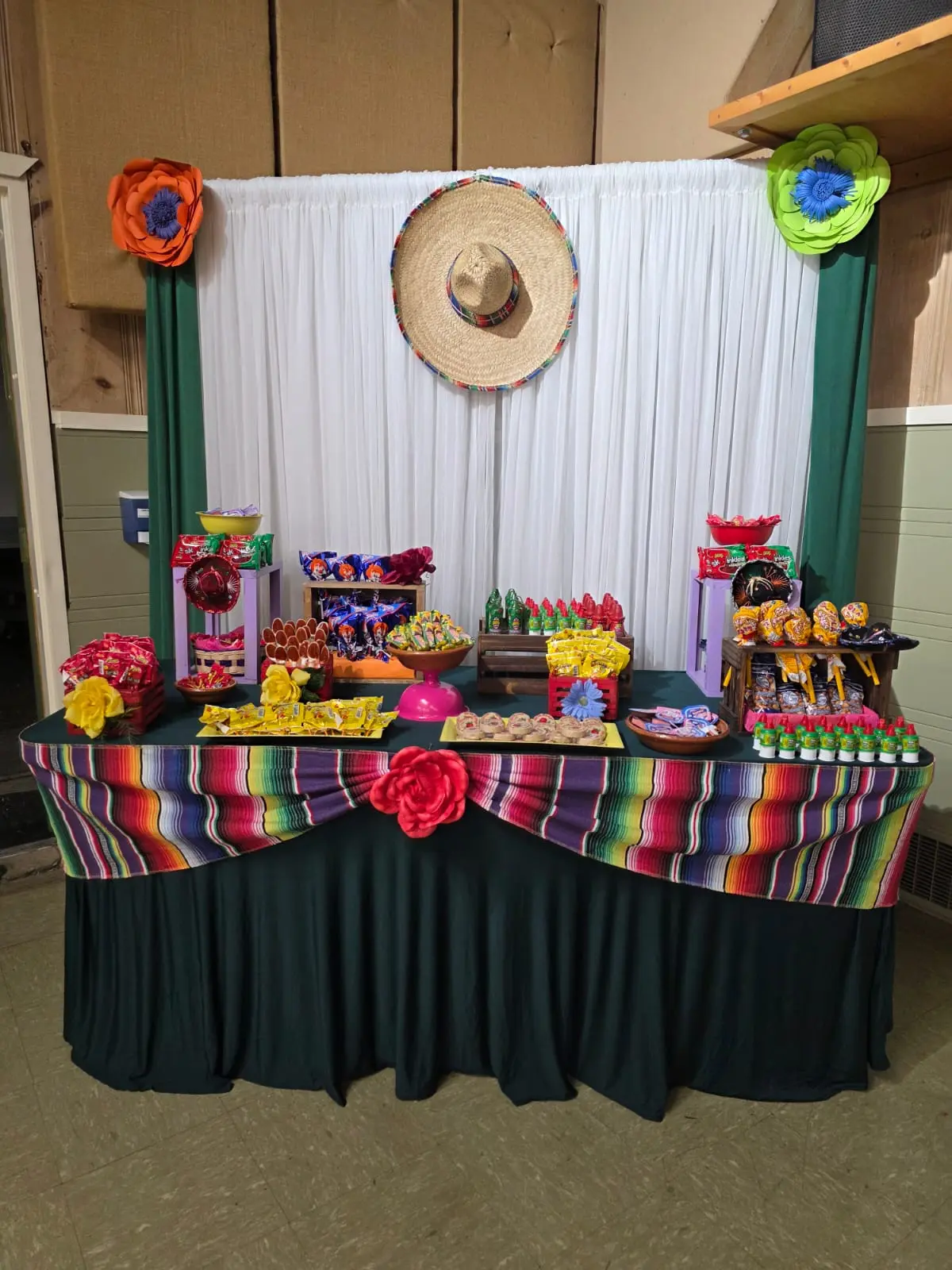 Candy table with traditional Mexican sweets and a large decorative sombrero